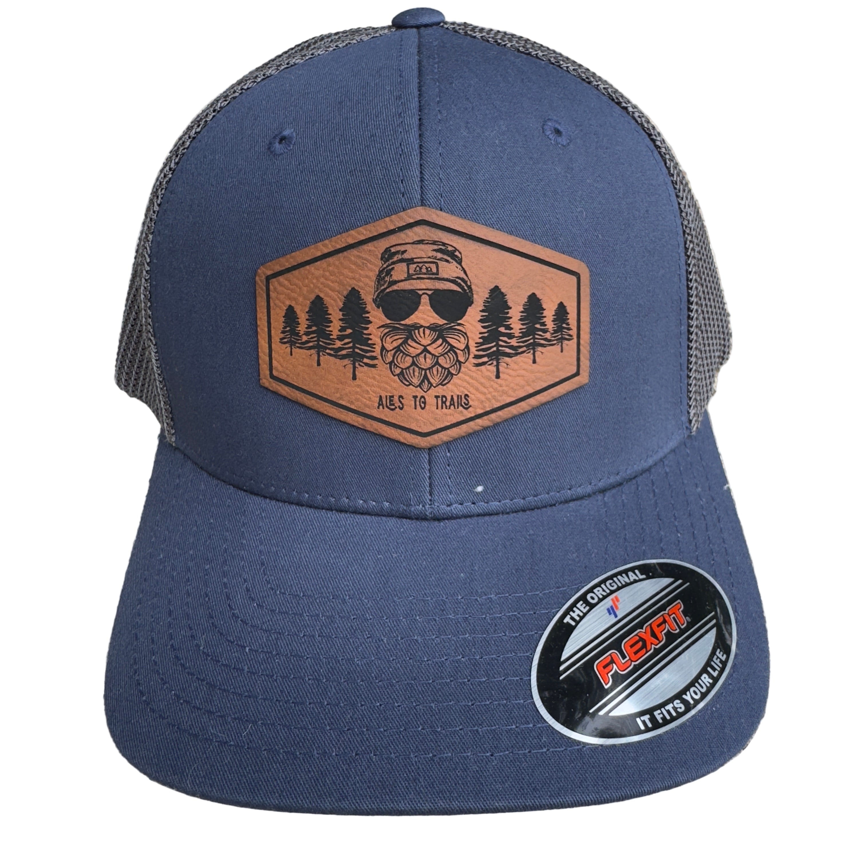 Fitted, breathable trucker hat with a curved brim and mesh back, designed for hikers, beer lovers, and outdoorsmen. The hat features a leather patch related to trails and craft beer. Keywords: