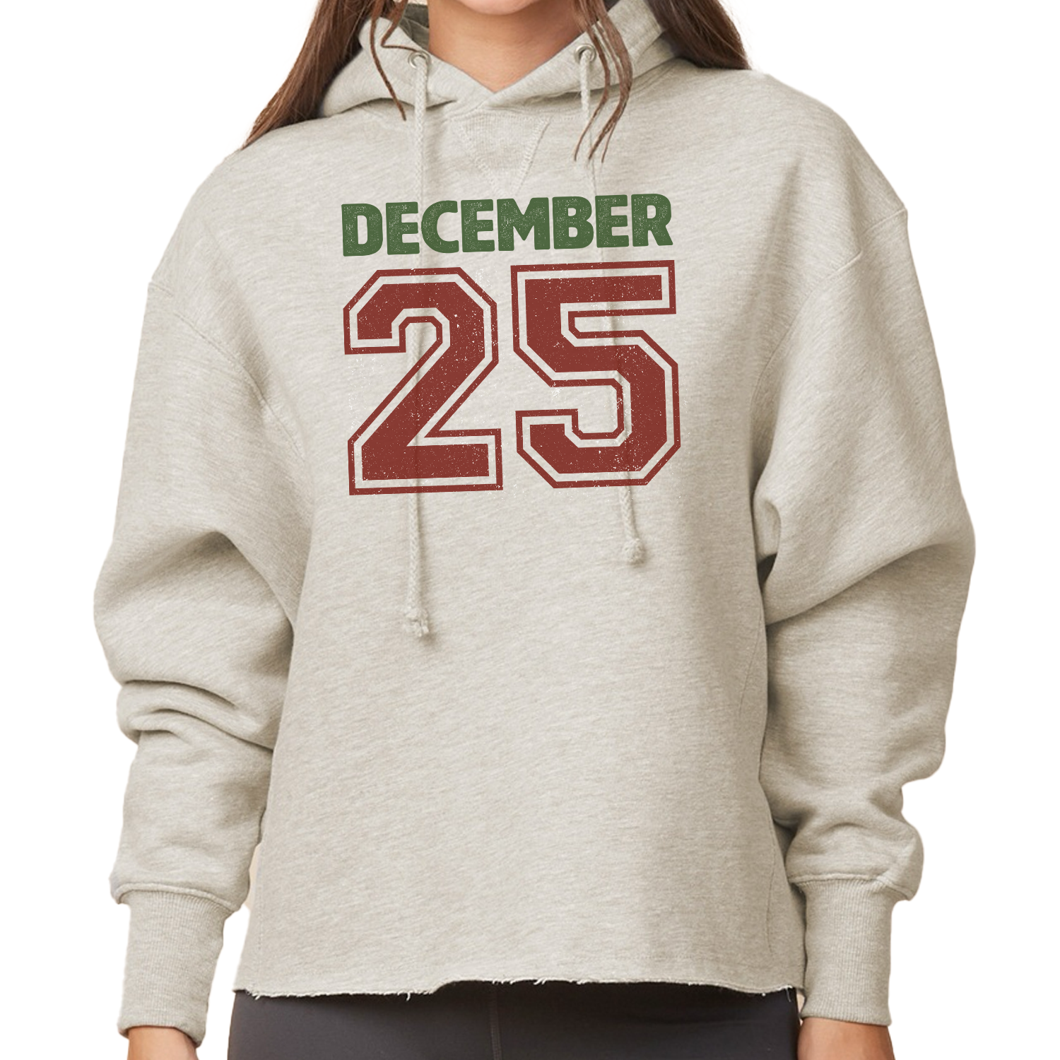 Women's boxy pullover hoodie in [Color, e.g., forest green] with "December 25th" printed in white collegiate font. Shows the relaxed fit.